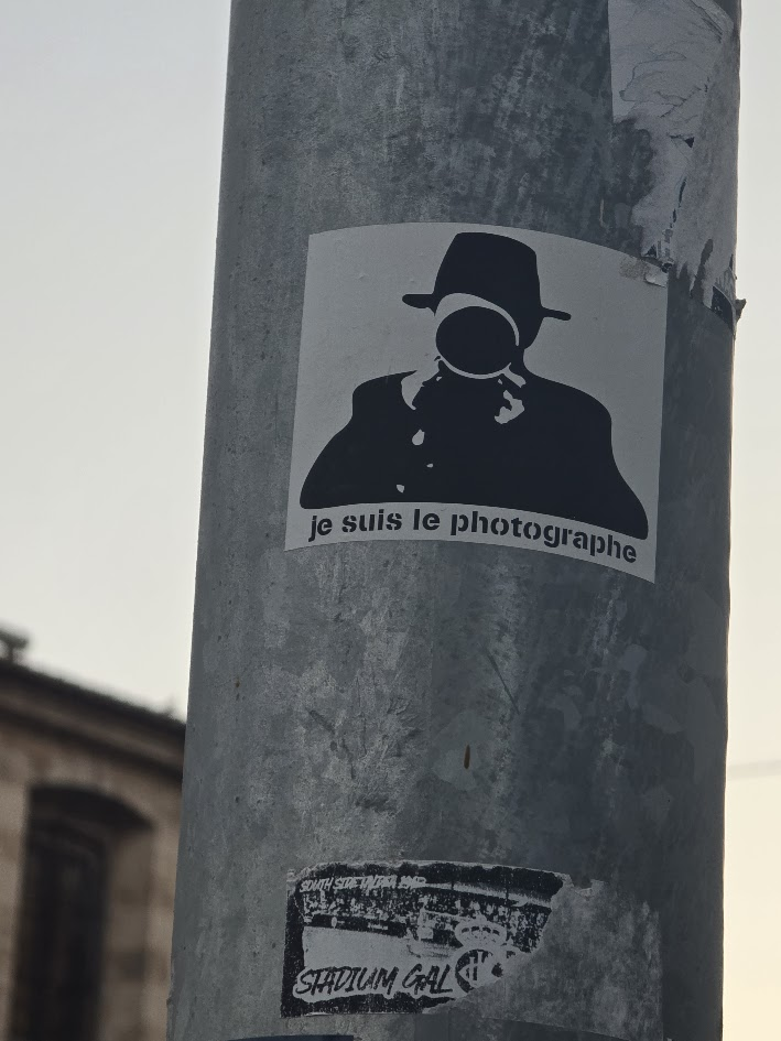 Pegatina 'je suis le photographe' en un poste de la calle