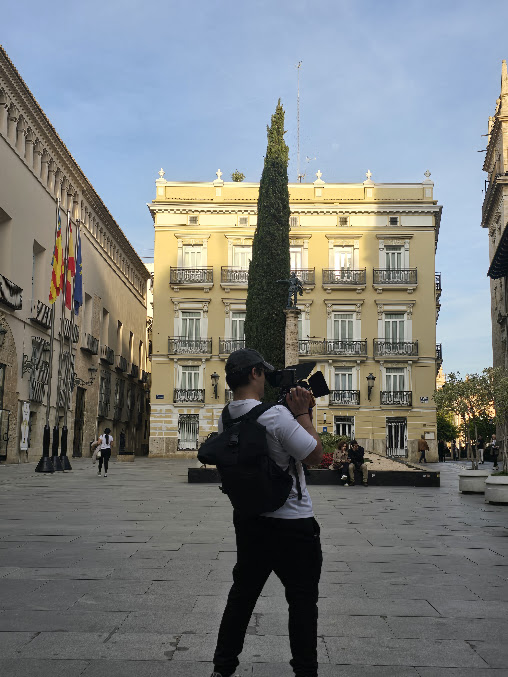 Cámara al hombro frente a un edificio del casco antiguo de Valencia