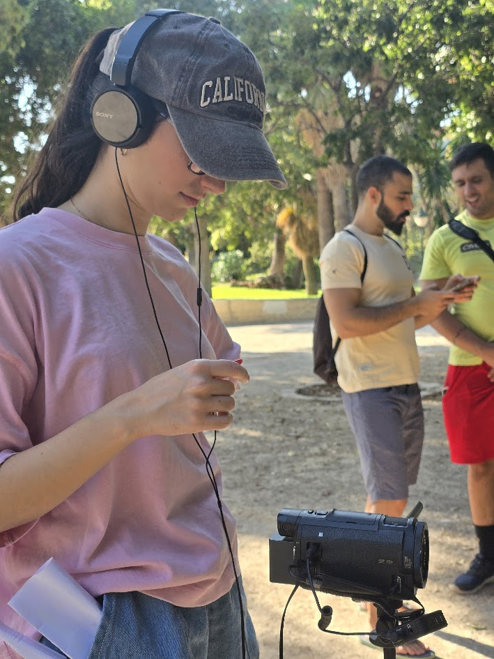 Miembro del equipo con auriculares revisando el sonido junto a la cámara