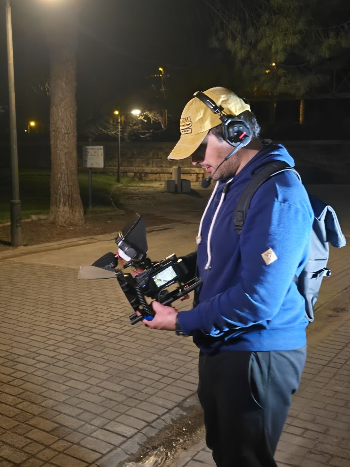 Camarógrafo con la cámara en mano durante el rodaje nocturno